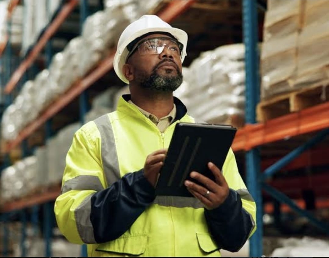 Warehouse supervisor reviewing building material supply inventory on a tablet